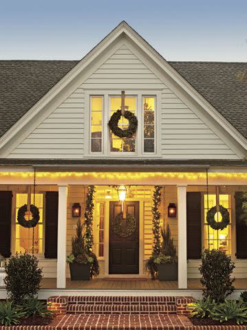 The decor starts with a simple arrangement of wreaths and garland. The golden, glowing lights bring major Christmas cheer to the home.