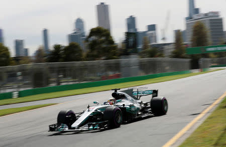 Formula One - F1 - Australian Grand Prix - Melbourne, Australia - 24/03/2017 Mercedes driver Lewis Hamilton of Britain passes the Melbourne skyline during the first practice session. REUTERS/Jason Reed