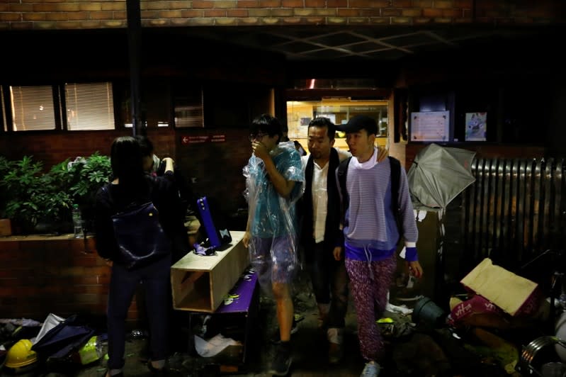 Anti-government demonstrators come out of the Hong Kong Polytechnic University (PolyU) to surrender, in Hong Kong