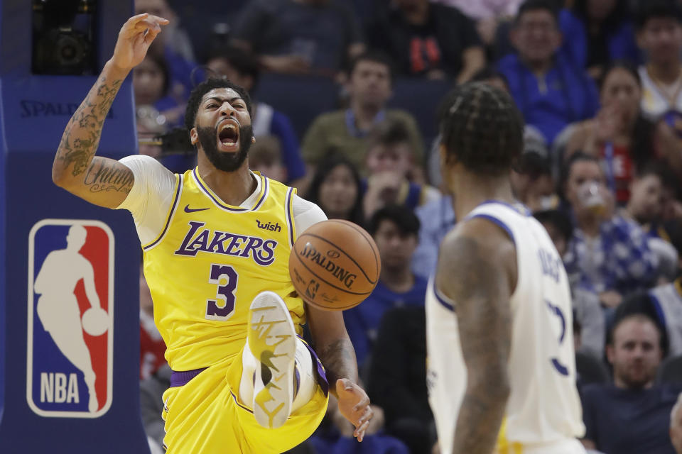 Los Angeles Lakers forward Anthony Davis (3) yells after dunking against the Golden State Warriors during the first half of a preseason NBA basketball game in San Francisco, Saturday, Oct. 5, 2019. (AP Photo/Jeff Chiu)