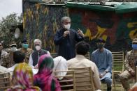 Pakistan's Foreign Minister Shah Mahmood Qureshi, center, addresses to villagers while Defense Minister Pervez Khattak, third left, looks on during their visit to forward area post along a highly militarized frontier in the disputed region of Kashmir, in Chiri Kot sector, Pakistan, Monday, Aug. 3, 2020. The region's top Pakistani military commander briefed ministers about Indian cease-fire violations in Kashmir, which is split between Pakistan and India and claimed by both in its entirety. (AP Photo/Anjum Naveed)