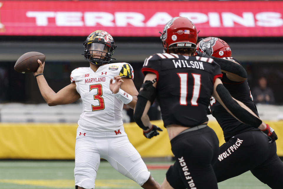 Maryland quarterback Taulia Tagovailoa (3) looks to pass as North Carolina State linebacker Payton Wilson (11) and defensive tackle Davin Vann close in during the first half of the Duke's Mayo Bowl NCAA college football game in Charlotte, N.C., Friday, Dec. 30, 2022. (AP Photo/Nell Redmond)