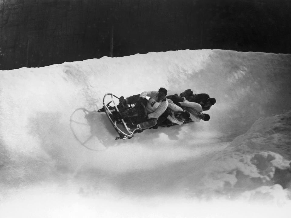 A  four-man bobsleigh team sliding down in the snow in 1924.