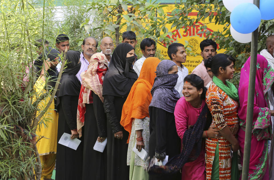 Indians stand in queues to cast their votes in Kasada village, in Kausambi district of Uttar Pradesh state, India, Monday, May 6, 2019. Voting began amid scorching summer temperatures and tight security in Uttar Pradesh in northern India, where more than 25 million people are registered to cast ballots for 14 members of India's Parliament. (AP Photo/Rajesh Kumar Singh)