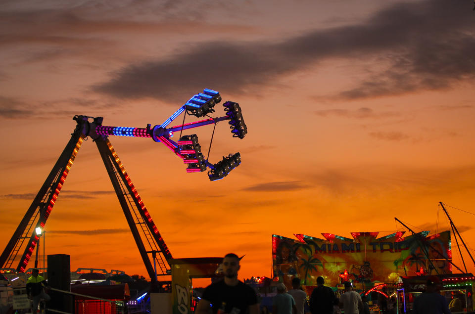 In this picture taken Thursday, Sept. 12, 2019, rides are backdropped by the sunset sky at an autumn fair in Titu, southern Romania. Romania's autumn fairs are a loud and colorful reminder that summer has come to an end and, for many families in poorer areas of the country, one of the few affordable public entertainment events of the year. (AP Photo/Vadim Ghirda)