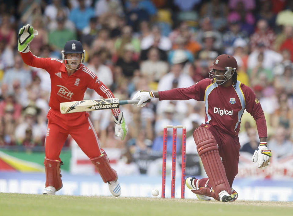 West Indies' Chris Gayle kneels down as he watches his shot as England's wicket keeper Jos Buttler screams during their first T20 International cricket match at the Kensington Oval in Bridgetown, Barbados, Sunday, March 9, 2014. (AP Photo/Ricardo Mazalan)