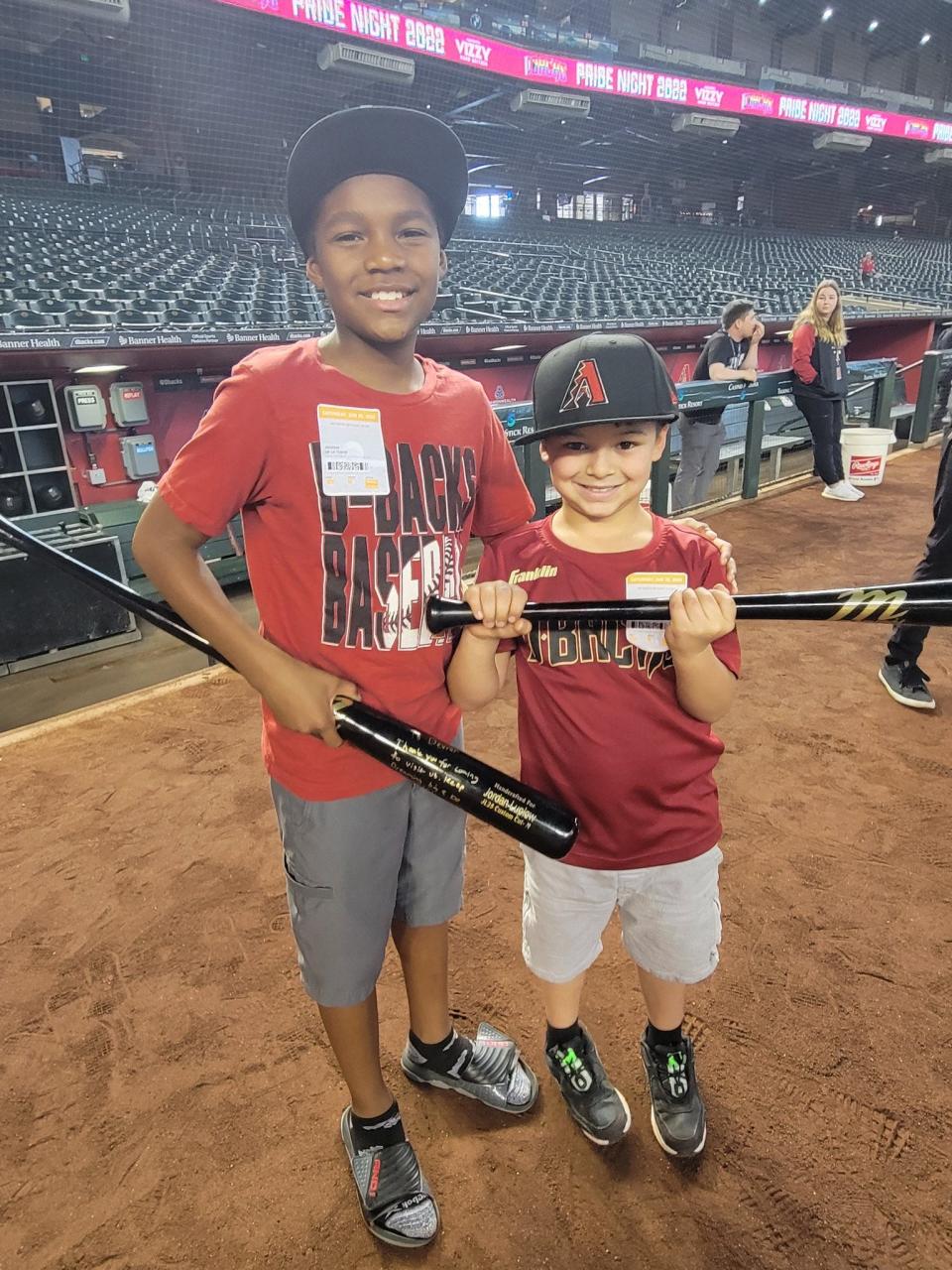 Devron De La Torre (left) and Carson Flores show off bats they received from the Diamondbacks' Jordan Luplow on Saturday night. The boys and their families were guests of the team to offer a respite from a year of turmoil dealing with fire and flood that destroyed the home of their grandparents and great-grandparents, respectively.