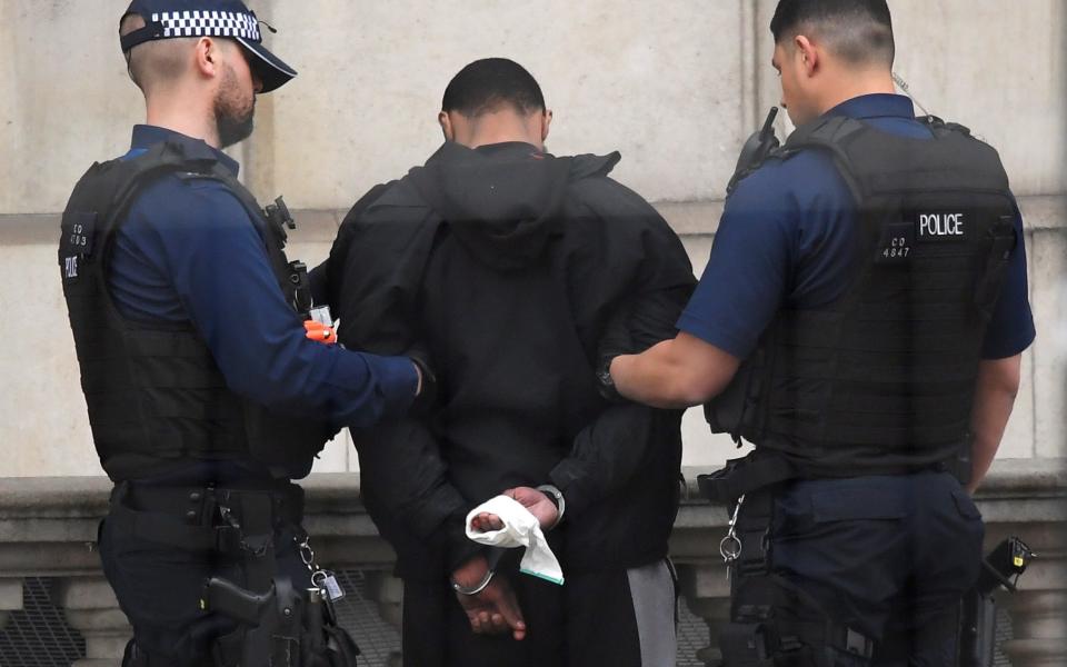 A man is held by police in Westminster after an arrest was made on Whitehall in central London - Credit: Reuters