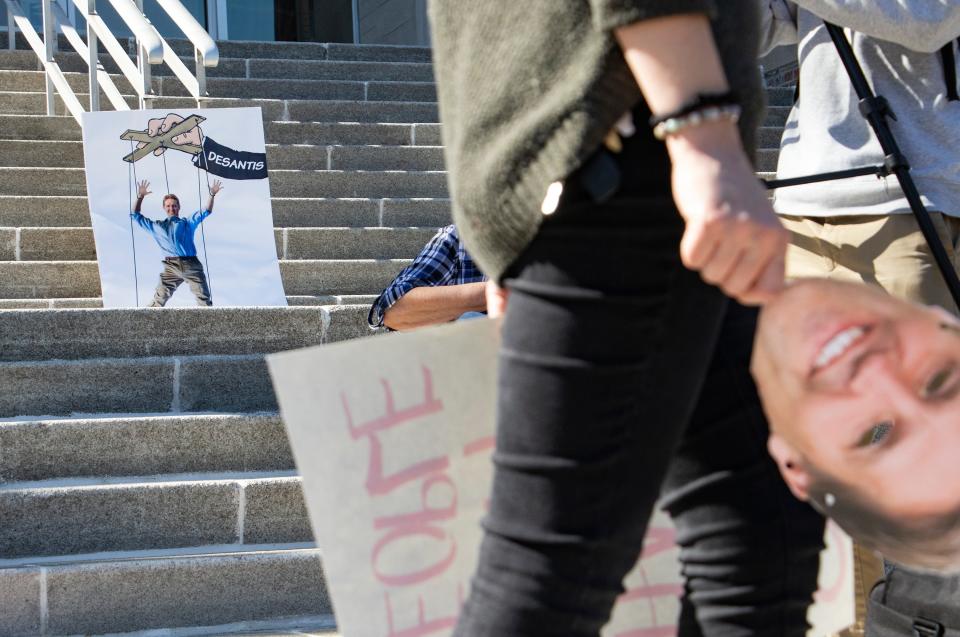 A sign depicting Ben Sasse as a puppet of DeSantis is pictured during the protest on the new president's first day leading the University of Florida.