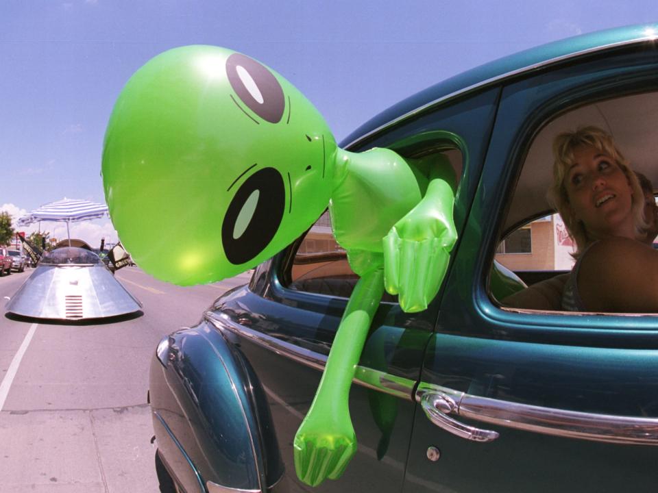 An inflatable alien dangles out a car window in Roswell, New Mexico