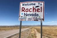 A sign reading "Welcome to Rachel Nevada" stands along the road in Rachel, Nevada