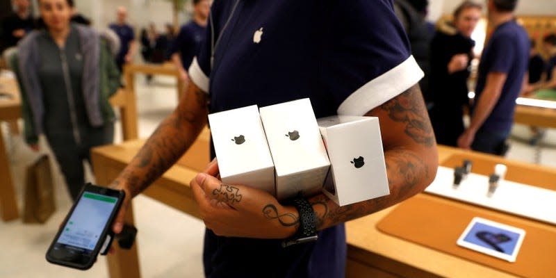 FILE PHOTO: An Apple Store staff shows Apple's new iPhones X after they go on sale at the Apple Store in Regents Street, London, Britain, November 3, 2017.   REUTERS/Peter Nicholls/File Photo