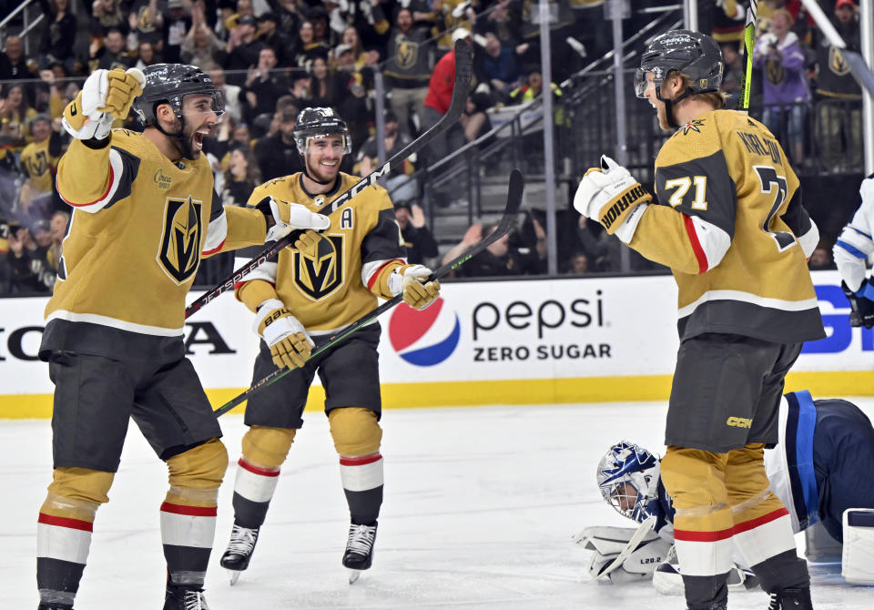 Vegas Golden Knights right wing Michael Amadio (22), right wing Reilly Smith (19) and center William Karlsson (71) celebrte Karlsson's goal against the Winnipeg Jets during the second period of Game 5 of an NHL hockey Stanley Cup first-round playoff series Thursday, April 27, 2023, in Las Vegas. (AP Photo/David Becker)