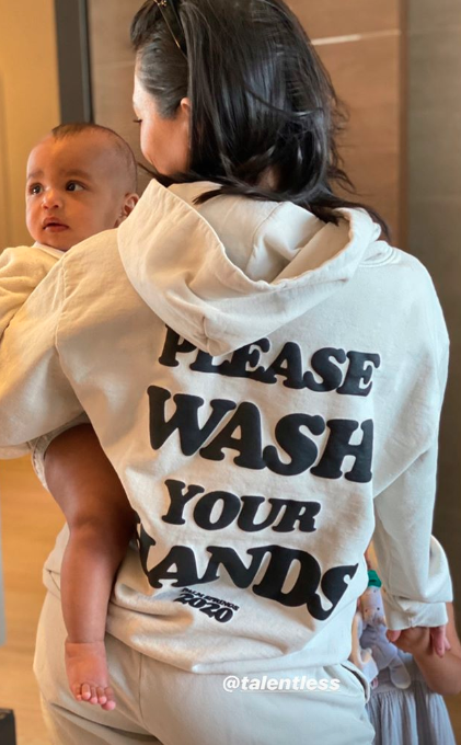 Kourtney Kardashian holding Psalm West in a Talentless jumper