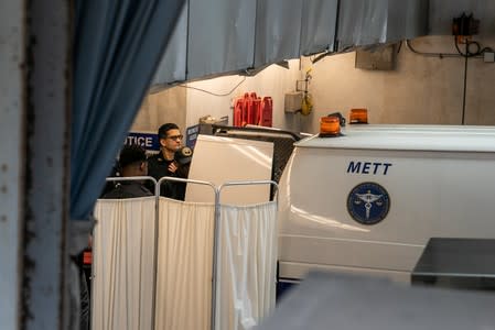 Police officers cover a medical examiner car outside New York Presbyterian-Lower Manhattan Hospital, where Jeffrey Epstein's body was transported in Manhattan borough of New York City