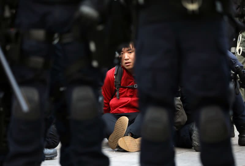 A protester is detained by riot police during the "Lest We Forget" rally in Hong Kong