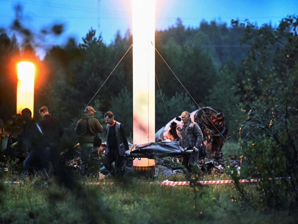 Emergency specialists carry a body bag near wreckages of the private jet linked to Wagner mercenary chief Yevgeny Prigozhin at the crash site in the Tver region, Russia, August 24, 2023.