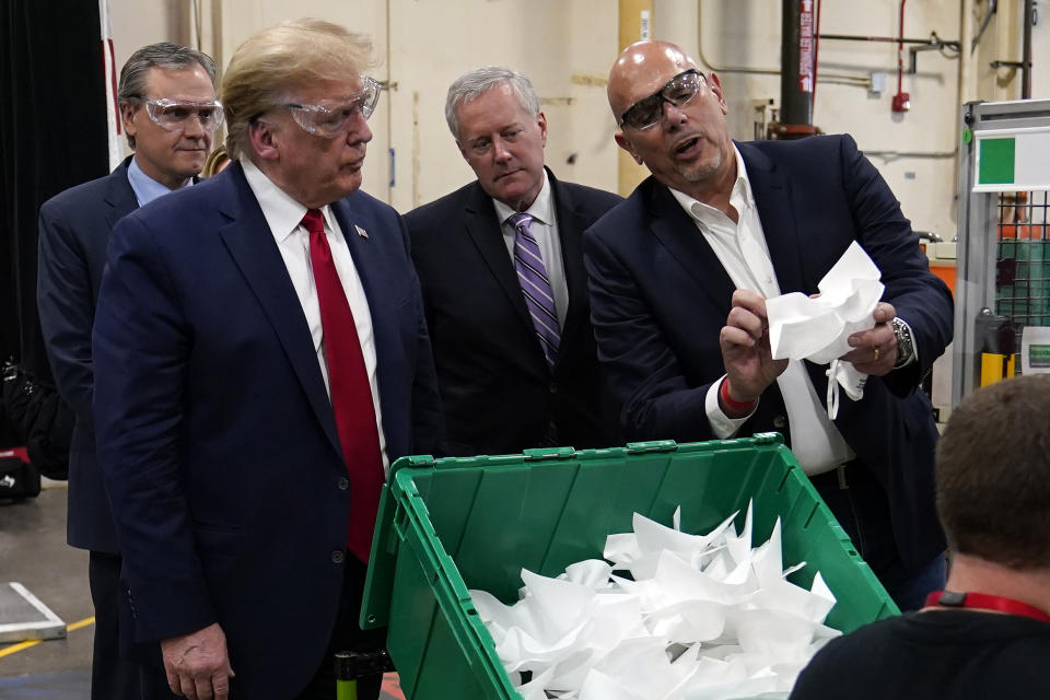 President Donald Trump listens to Tony Stallings, vice president of integrated supply chain at Honeywell International Inc., right, during a tour of a Honeywell International plant that manufactures personal protective equipment, Tuesday, May 5, 2020, in Phoenix. At left is Honeywell CEO Darius Adamczyk and White House chief of staff Mark Meadows. (AP Photo/Evan Vucci)