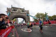 <p>Runners at the London Marathon celebrate as supporters watch on </p>