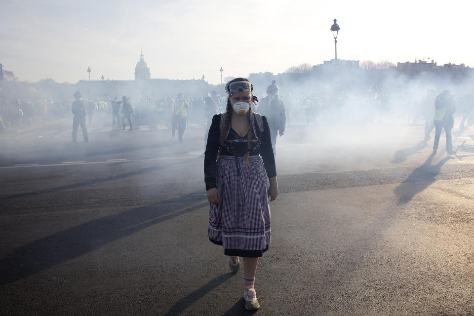 A protester walks away during scuffles Saturday, Feb.16, 2019 in Paris. Hundreds of yellow vest protesters marched through Paris, one of seven scattered demonstrations in the French capital Saturday, for the 14th straight weekend. (AP Photo/Thibault Camus)