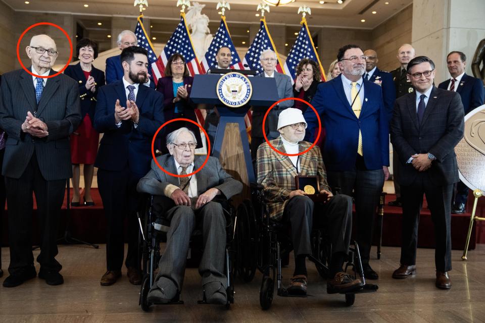 Veterans Bernie Bluestein, in a wheelchair on the right, Seymour Nussenbaum, in a wheelchair on the left, and John Christman, standing on the left, are applauded as their unit received the Congressional Gold Medal.