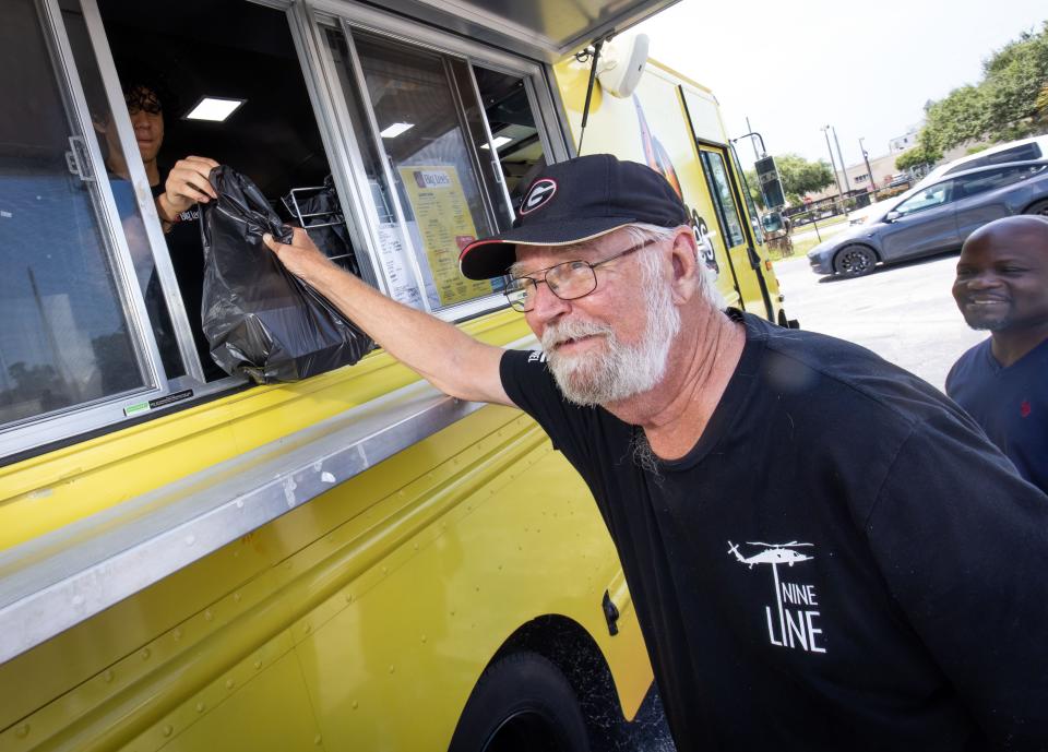 Earl Waldron of Savannah, Georgia picks up his lunch order from Big Lee's BBQ food truck Wednesday in downtown Ocala.