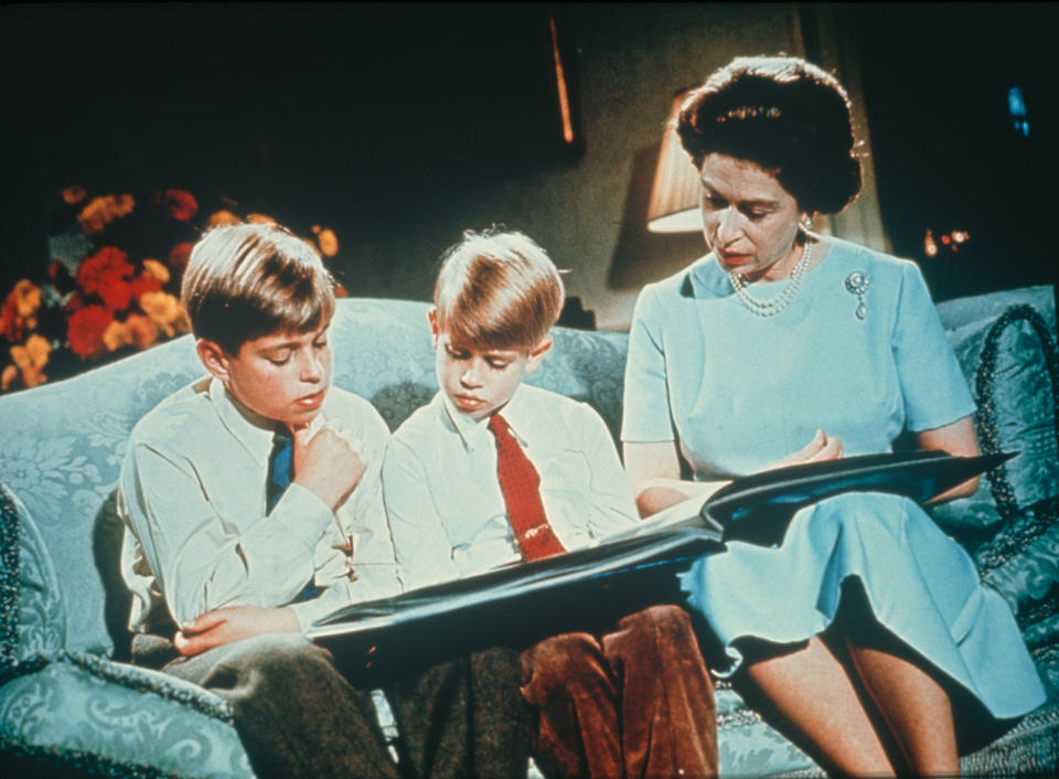 Queen Elizabeth II looking at a photograph album with her sons Prince Andrew (left) and Prince Edward, December 1971. Footage of this scene was used in the Queen's Christmas Broadcast of 1971, to illustrate the theme of family. (Photo by Hulton Archive/Getty Images)