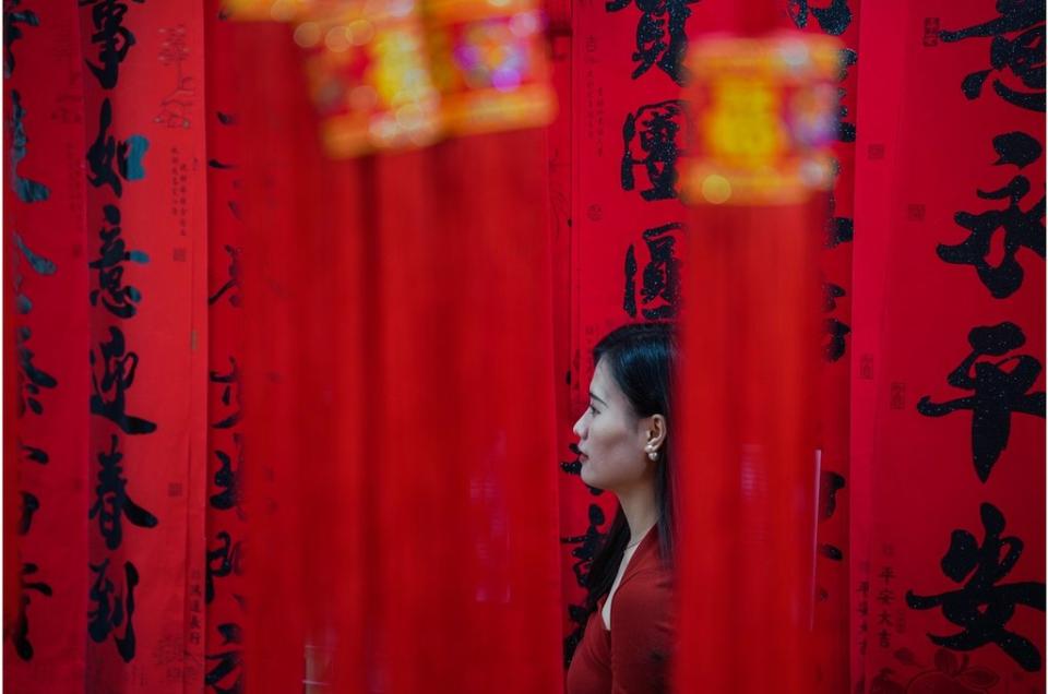 廣西南寧一名婦女在即將到來的中國農曆新年前購買紅燈籠和對聯裝飾