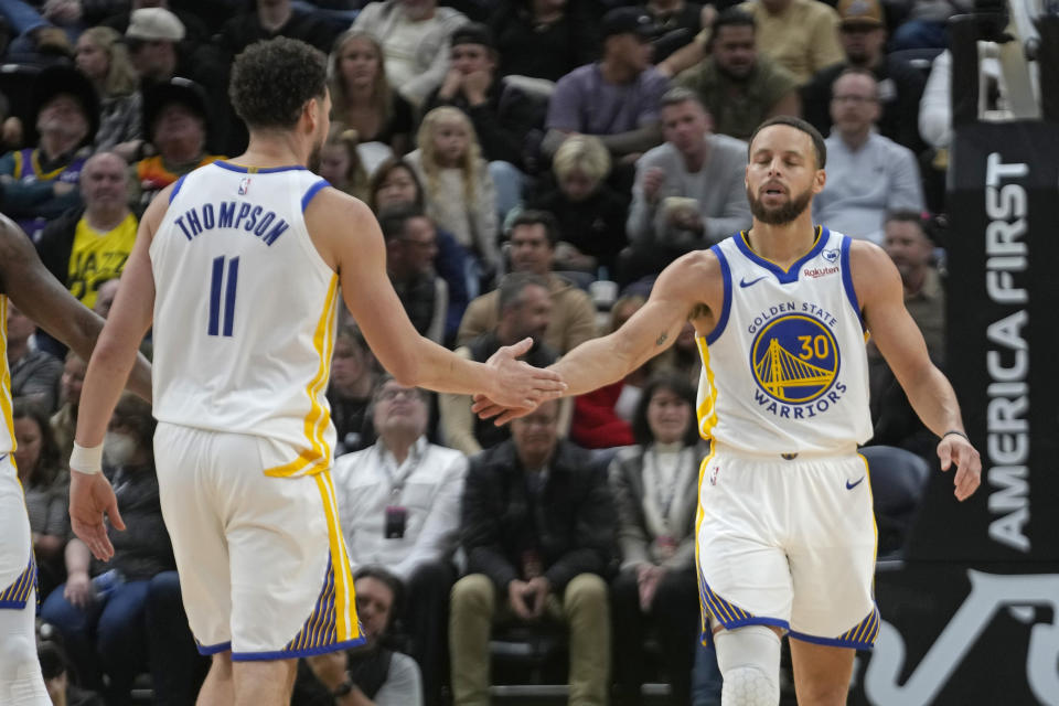 Golden State Warriors' Klay Thompson (11) and Stephen Curry (30) celebrate during the second half of an NBA basketball game against the Utah Jazz Monday, Feb. 12, 2024, in Salt Lake City. (AP Photo/Rick Bowmer)