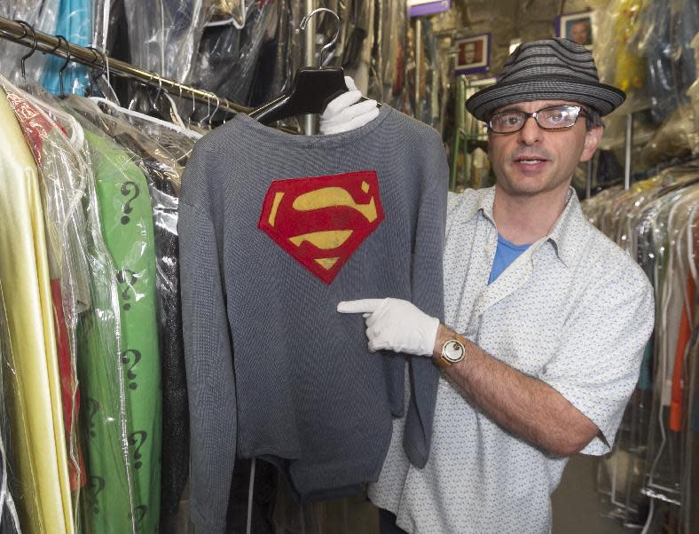 In this Friday, Nov. 30, 2012 photo, James Comisar holds the costume George Reeves wore in the 1950s TV show "Adventures of Superman." The item is part of his television memorabilia collection in a temperature- and humidity-controlled warehouse in Los Angeles. (AP Photo/Damian Dovarganes)