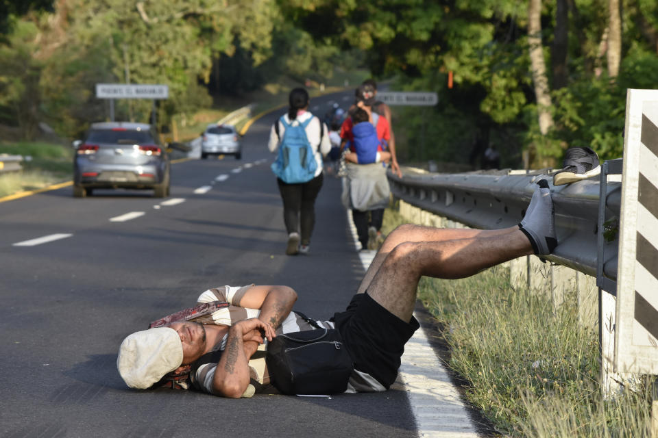 Un migrante descansa durante su caminata hacia el norte como parte de la caravana de migrantes que avanza por la autopista en Villa Comaltitlán, en el estado de Chiapas, al sur de México, el miércoles 27 de diciembre de 2023. (AP Foto/Édgar H. Clemente)