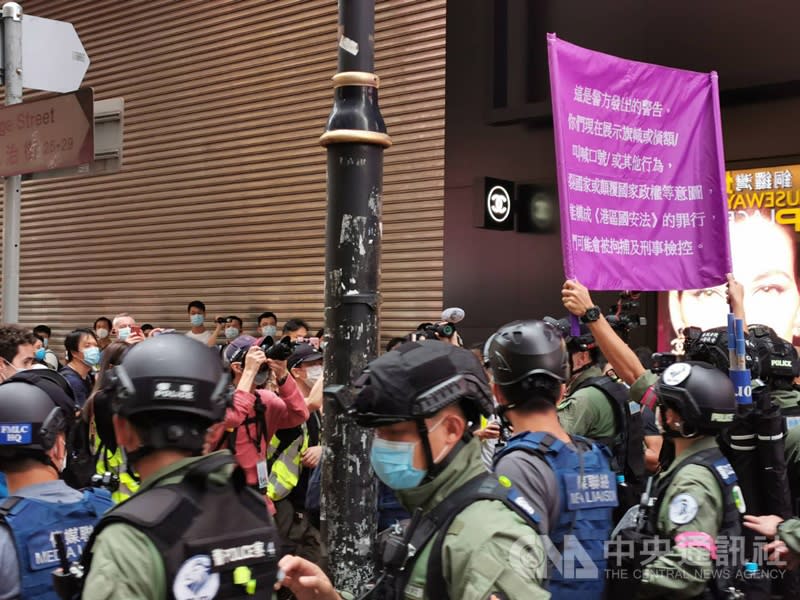 香港一批「反送中」運動支持者今天不理會警方禁制，自行到港島銅鑼灣一帶聚集，他們高叫「時代革命，光復香港」等「港獨」口號。防暴警察舉起紫旗，警告他們已經違反國安法。(中央社) 