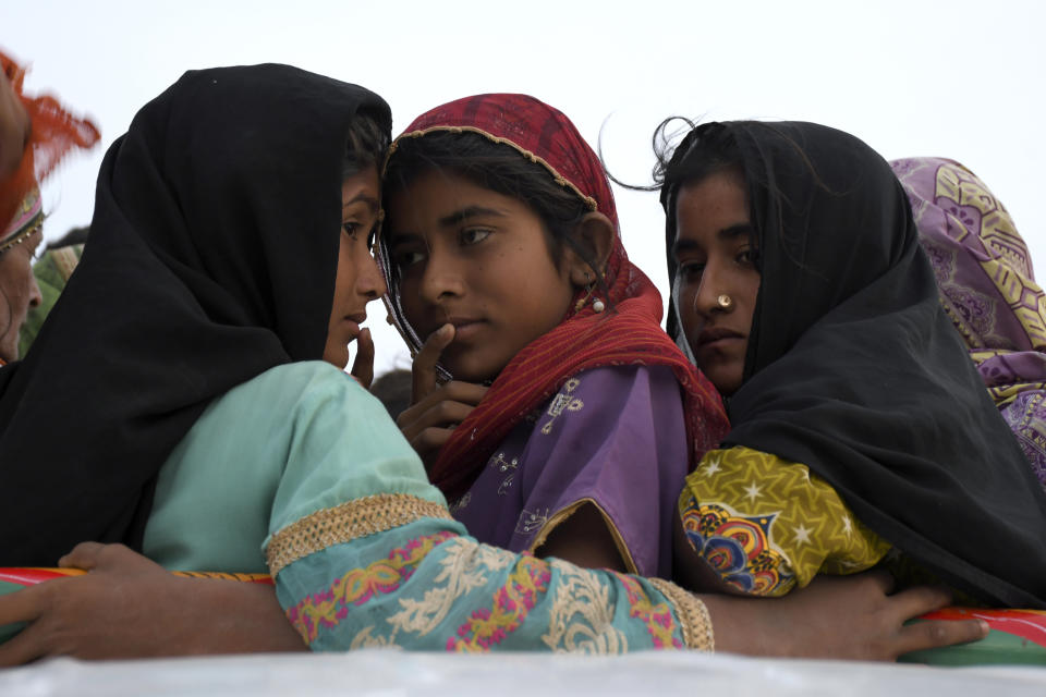 Girls travel in a vehicle as they evacuate with their families due to Cyclone Biparjoy approaching, at a costal area Golarchi in Badin district, in Pakistan's Sindh province, Tuesday, June 13, 2023. Pakistan's army and civil authorities are planning to evacuate 80,000 people to safety along the country's southern coast, and thousands in neighboring India sought shelter ahead of Cyclone Biparjoy, officials said. (AP Photo/Umair Rajput)