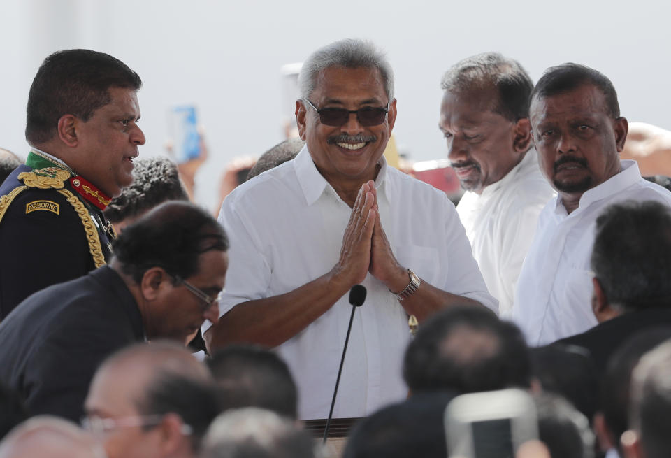 Sri Lanka's newly elected president Gotabaya Rajapaksa greets people as he arrive for the swearing in ceremony held at the 140 B.C Ruwanweli Seya Buddhist temple in ancient kingdom of Anuradhapura in northcentral Sri Lanka Monday, Nov. 18, 2019. The former defense official credited with ending a long civil war was Monday sworn in as Sri Lanka’s seventh president after comfortably winning last Saturday’s presidential election. (AP Photo/Eranga Jayawardena)