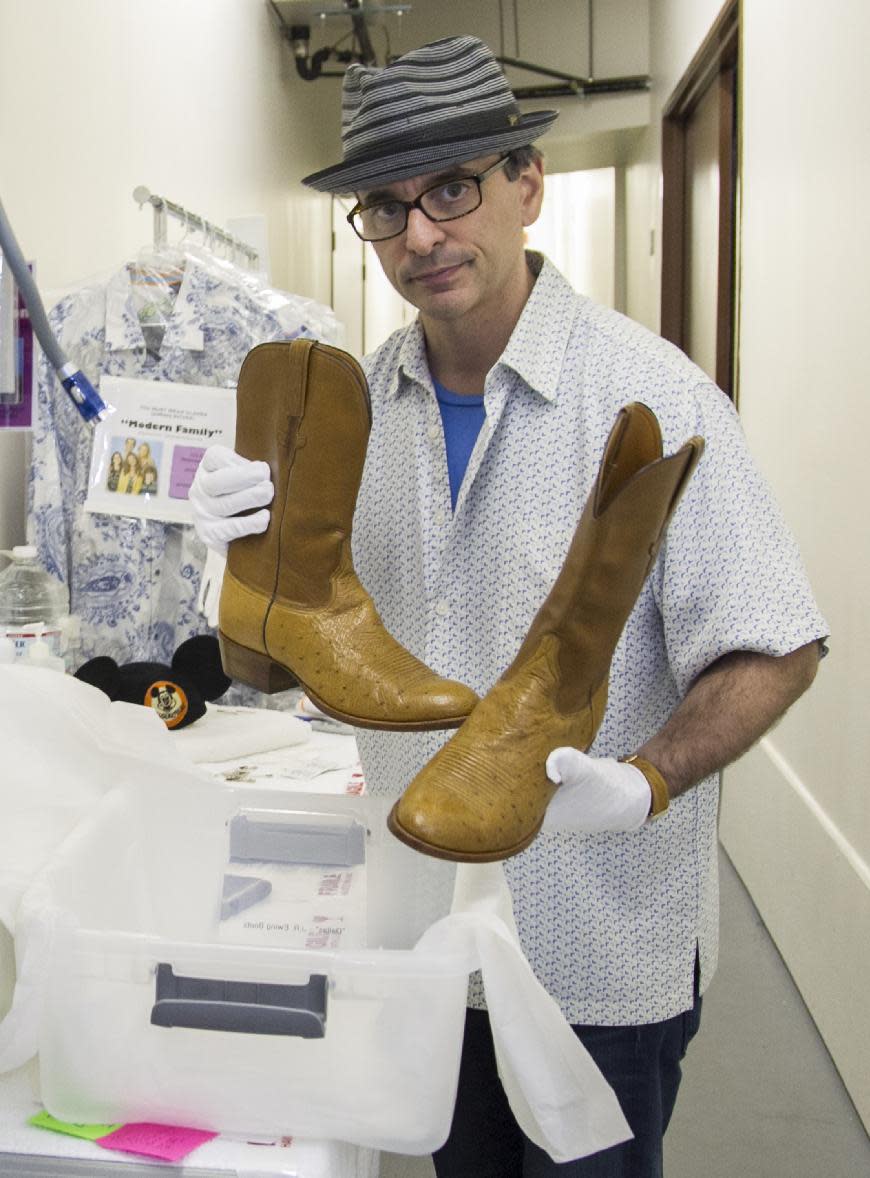 In this Friday, Nov. 30, 2012 photo, James Comisar shows boots worn by actor Larry Hagman as oil tycoon J. R. Ewing in the TV show "Dallas." The item is part of his television memorabilia collection in a temperature- and humidity-controlled warehouse in Los Angeles. (AP Photo/Damian Dovarganes)