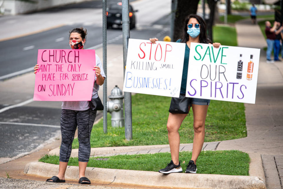 Demonstrators hold up signs during a 