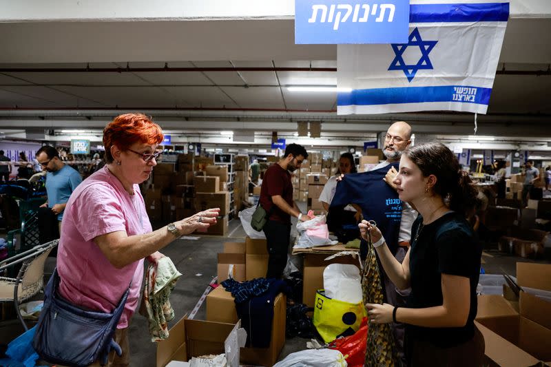 Volunteers sort boxes of donated humanitarian supplies at a logistical centre to support those impacted by the deadly infiltration by Hamas gunmen from the Gaza Strip, in Tel Aviv