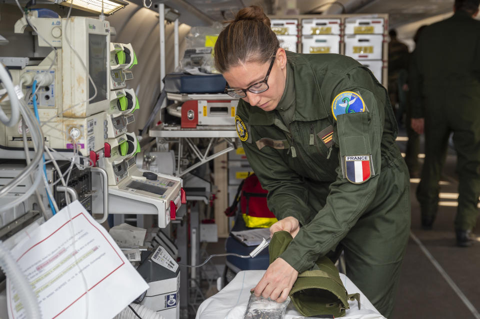 In this photo provided by the French Army, military doctors prepare medical equipment as they fly from Istres, southern France, to Mulhouse, eastern France, a region hardly hit by the coronavirus pandemic, Wednesday, March 18, 2020. The Airbus contains a military hospital and is used on military missions outside of France. This is the first time it will be used on French soil to take coronavirus patients and help the local hospitals in eastern regions. For most people, the new coronavirus causes only mild or moderate symptoms. For some it can cause more severe illness. (Olivier Fabre/DICOD via AP)