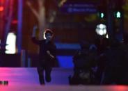 A hostage runs out of a cafe in the central business district of Sydney on December 16, 2014