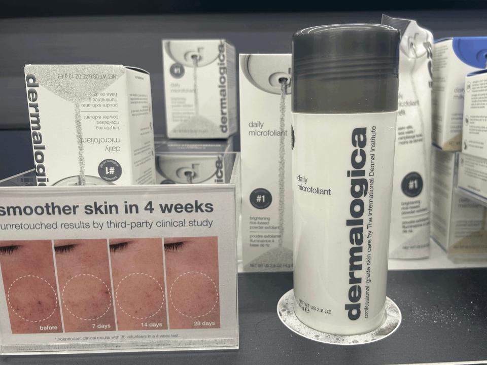 White container of Dermalogica daily microexfoliant on a shelf at Sephora. A chart of showing textured skin sits next to the bottle