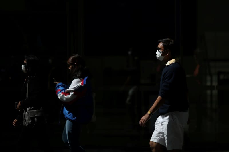 FILE PHOTO: Pedestrians wear protective face masks amidst fears of the coronavirus disease (COVID-19) in Sydney