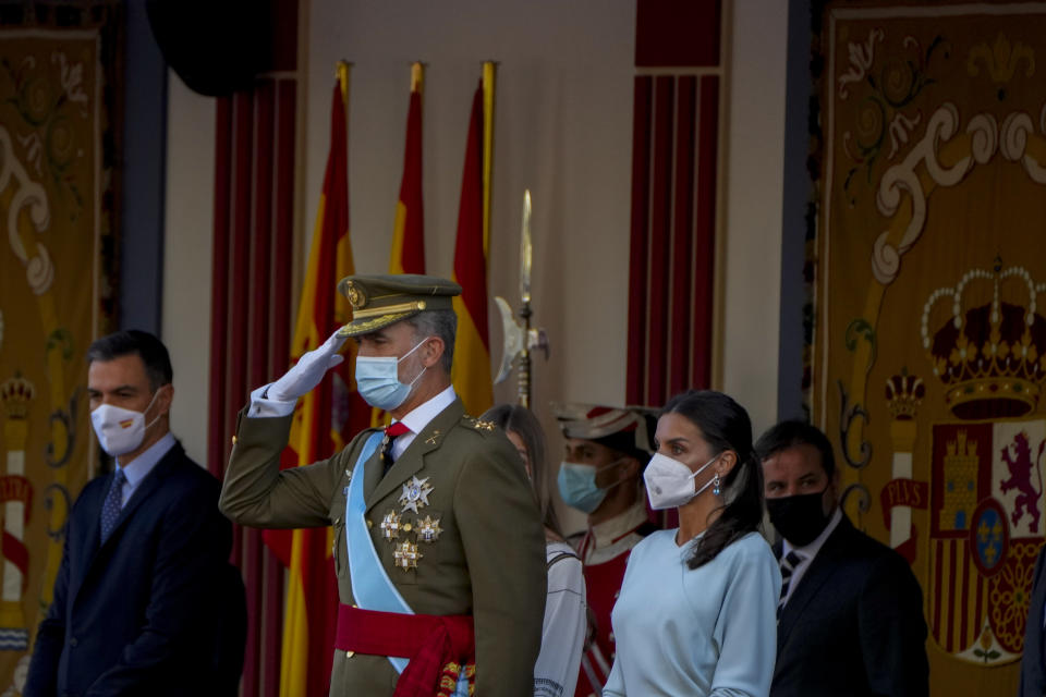 Spain's King Felipe, center, salutes next to Queen Letizia, right, during a military parade to celebrate a holiday known as 'Dia de la Hispanidad' or Hispanic Day in Madrid, Spain, Tuesday, Oct. 12, 2021. Spain commemorates Christopher Columbus' arrival in the New World and also Spain's armed forces day. (AP Photo/Manu Fernandez)