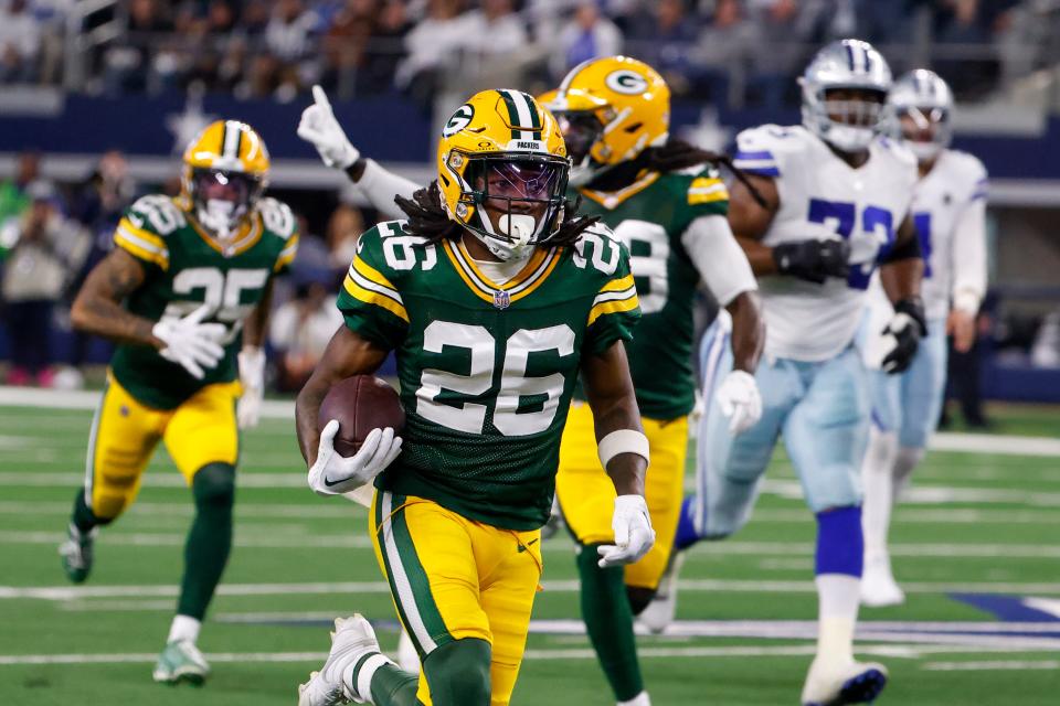 Green Bay Packers safety Darnell Savage (26) runs with the ball after making an interception on a pass by Dallas Cowboys quarterback Dak Prescott during the first half of an NFL football game, Sunday, Jan. 14, 2024, in Arlington, Texas. Savage scored on the return.