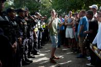 A Cuban migrant tries to calm down his fellow migrants as they protest in front of policemen while waiting for the opening of the border between Costa Rica and Nicaragua in Penas Blancas, Costa Rica November 17, 2015. More than a thousand Cuban migrants hoping to make it to the United States were stranded in the border town of Penas Blancas, Costa Rica, on Monday after Nicaragua closed its border on November 15, 2015 stoking diplomatic tensions over a growing wave of migrants making the journey north from the Caribbean island. REUTERS/Oswaldo Rivas