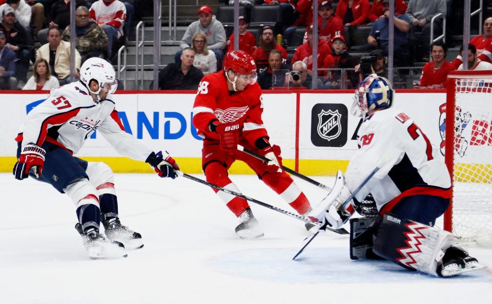 Red Wings right wing Patrick Kane takes a shot on goal against Capitals defenseman Trevor van Riemsdyk and goaltender Charlie Lindgren during the second period on Tuesday, Feb. 27, 2024, at Little Caesars Arena.