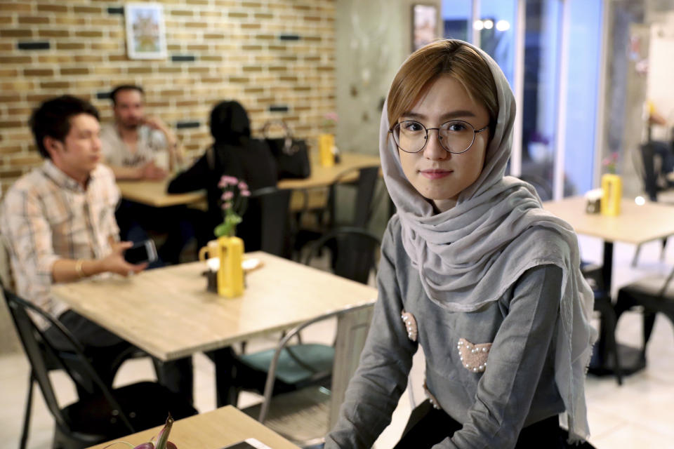 In this Monday, Oct. 7, 2019 photo, 21-year-old Afghan refugee Fatemeh Jafari poses for a photo at her basement Tehran coffee shop, in downtown Tehran, Iran. More than 3 million Afghans including as many as 2 million who entered without legal permission, live in the Islamic Republic, according to United Nations estimates. Jafari hopes her Telma, or “Dream,” Café in Tehran will help bridge the divides and xenophobia Afghans can face in Iran. (AP Photo/Ebrahim Noroozi)