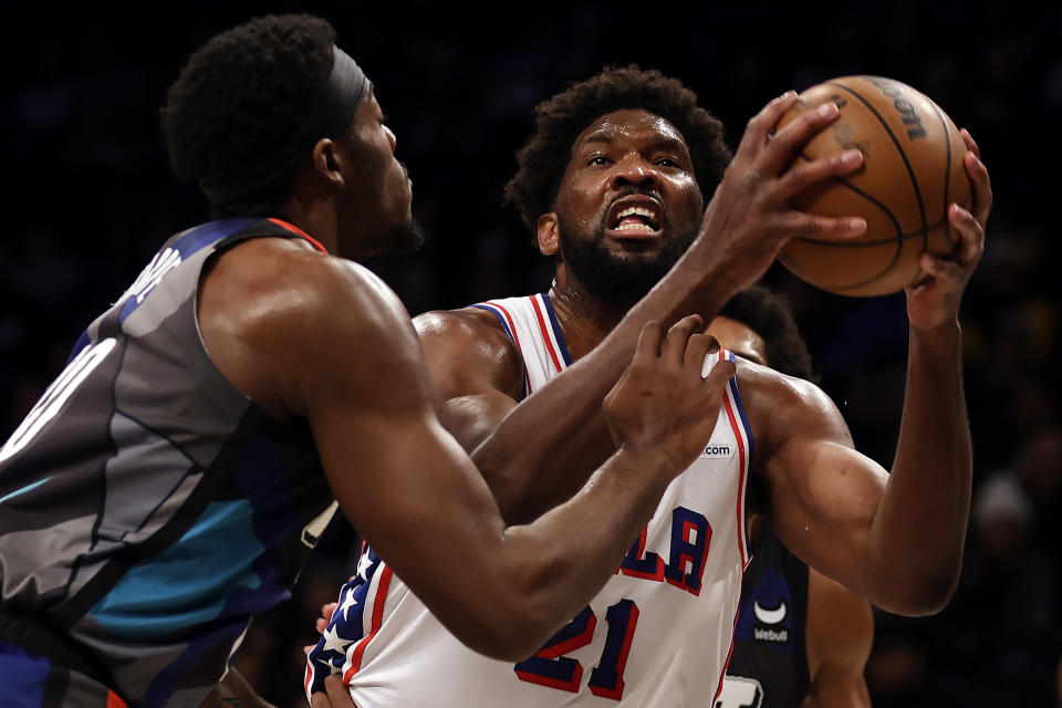 Philadelphia 76ers center Joel Embiid drives to the basket past Brooklyn Nets center Day'Ron Sharpe during the first half of an NBA basketball game, Sunday, Nov. 19, 2023, in New York. (AP Photo/Adam Hunger)