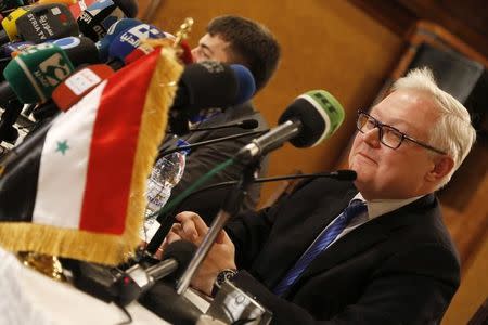 Russia's Deputy Foreign Minister Sergei Ryabkov sits near the Syrian national flag as he addresses a news conference in Damascus in this file photo dated June 28, 2014. Ryabkov, on a trip to Damascus, calls for a united effort with the U.S. and Europe to combat militancy in the Middle East. REUTERS/Omar Sanadiki