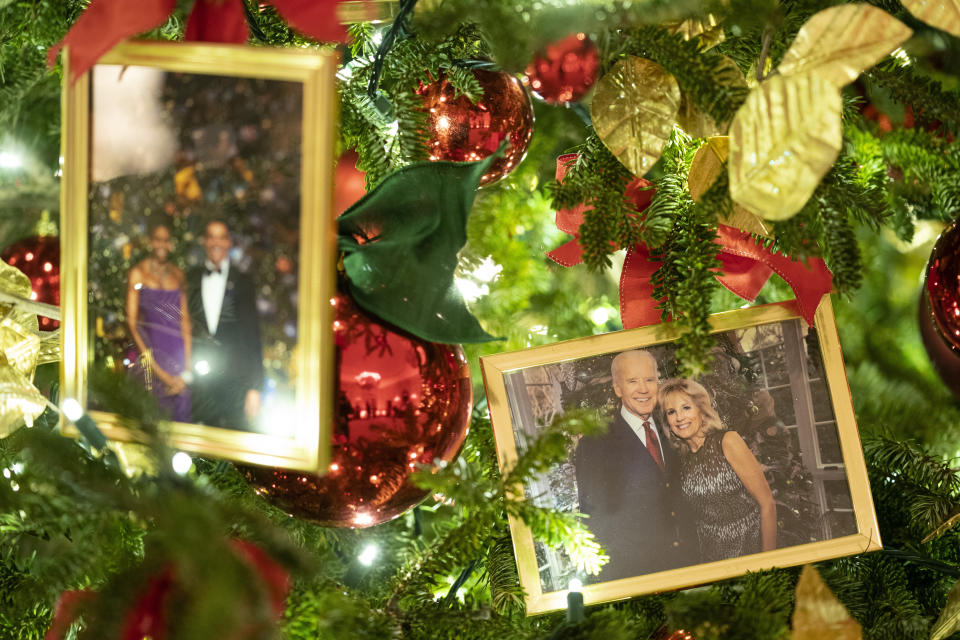 FILE - A photo of President Joe Biden and first lady Jill Biden sits in a Christmas tree in the State Dining Room of the White House during a press preview of the White House holiday decorations, Nov. 29, 2021, in Washington. In pre-pandemic times, presidents and first ladies spent many evenings in December before Christmas hosting nearly two dozen holiday parties and receptions, sometimes two per day, where they stood in line for hours to pose for photos with ecstatic guests. (AP Photo/Evan Vucci, File)