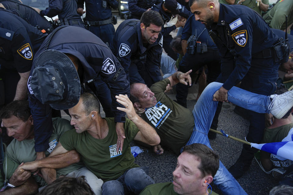 Israeli police disperse demonstrators, mostly military reservists, who block a road outside the house of Israeli Justice Minister Yariv Levin during a protest against plans by Prime Minister Benjamin Netanyahu's government to overhaul the judicial system, in Modiin, Israel, Monday, Sept. 11, 2023. (AP Photo/Ohad Zwigenberg)